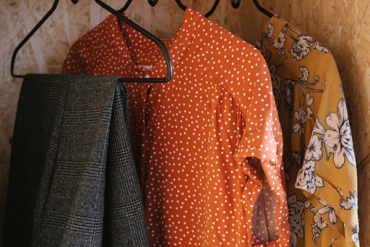 Vibrant clothes hanging on metal hangers showcasing diverse patterns and styles.